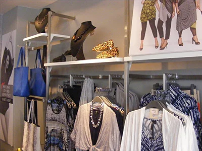 Dymonds-Metal-Retail-display-equipment-in-Stainless-Steel-for-Taking-Shape A sophisticated arrangement adult-wear including blouses, jewellery and shoes in a Taking Shape shop with shop fittings by Dymond Engineering